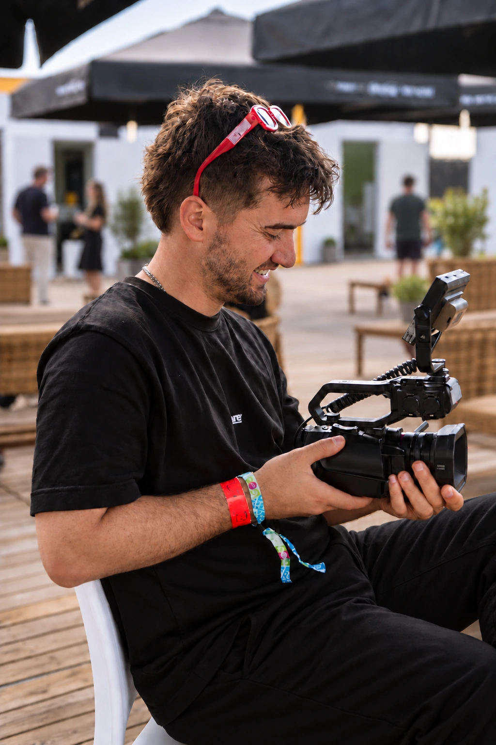 Sacha Vitali en tournage, caméra en main et lunettes rouges sur la tête